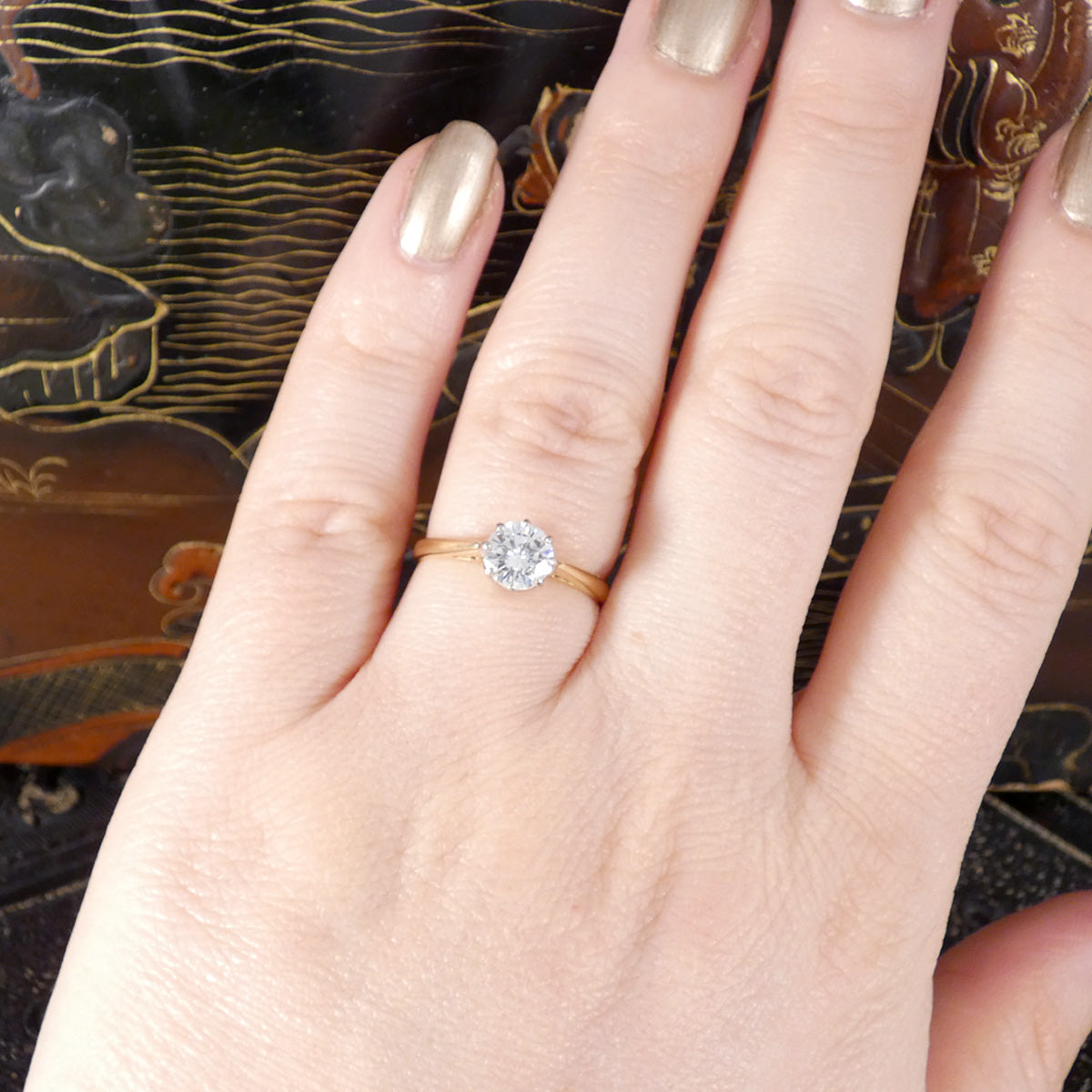 The perfect diamond solitaire ring with a bright and lively appearance shown worn on the hand on the ring finger.