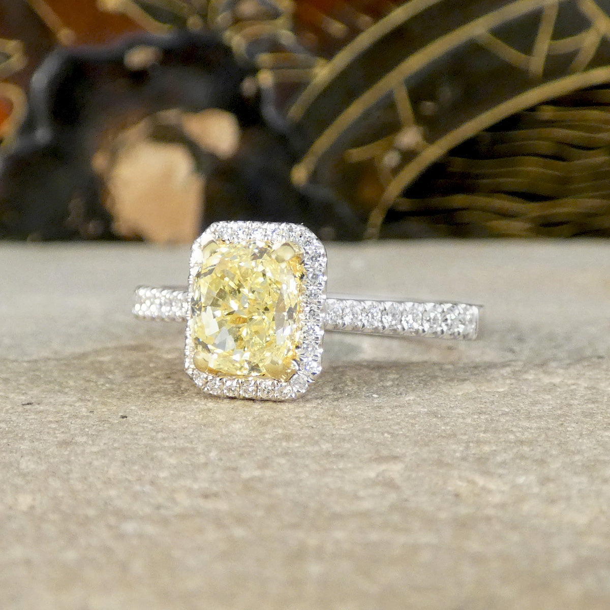 Diamond ring with a yellow gemstone on a textured surface