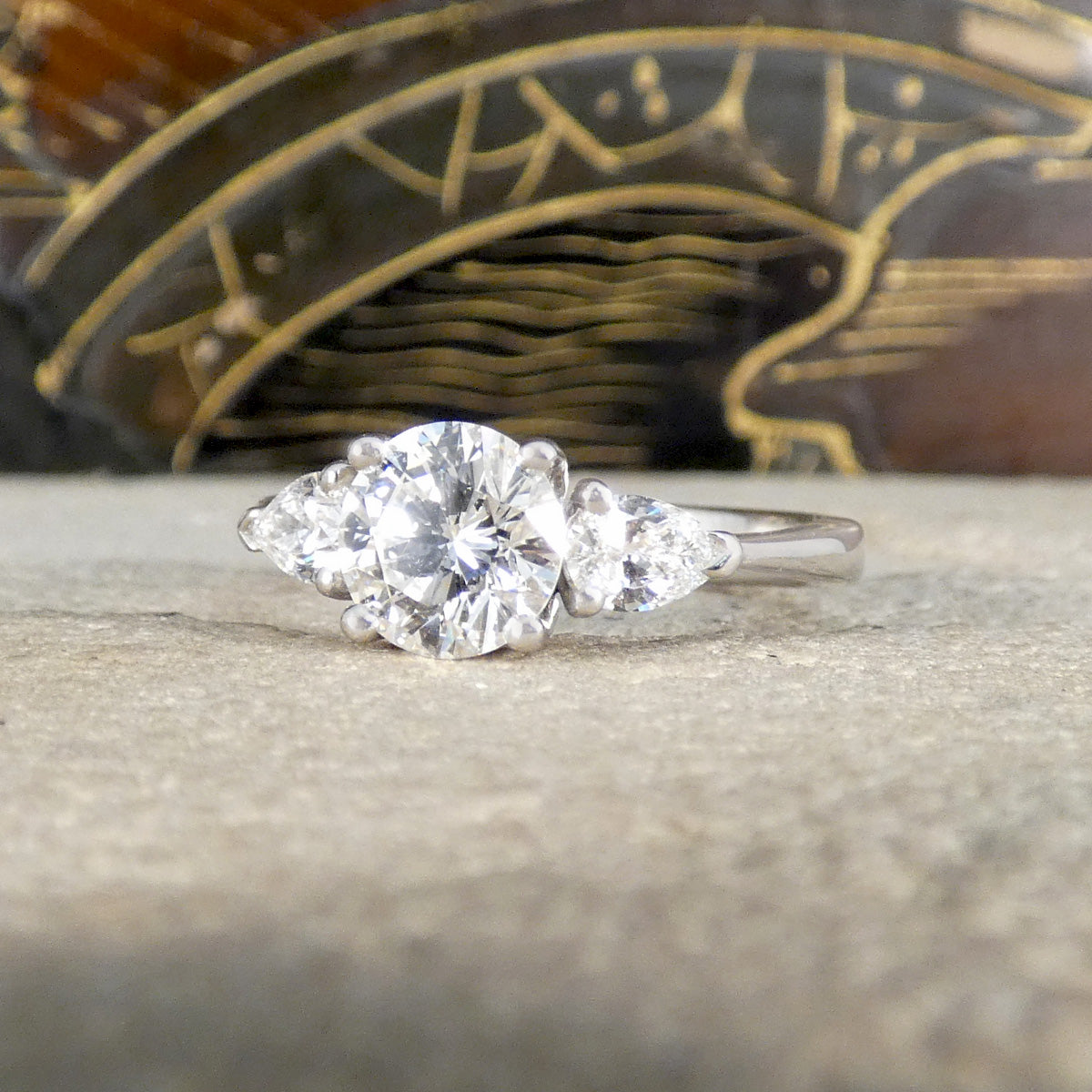 Diamond ring on a textured surface with a decorative background
