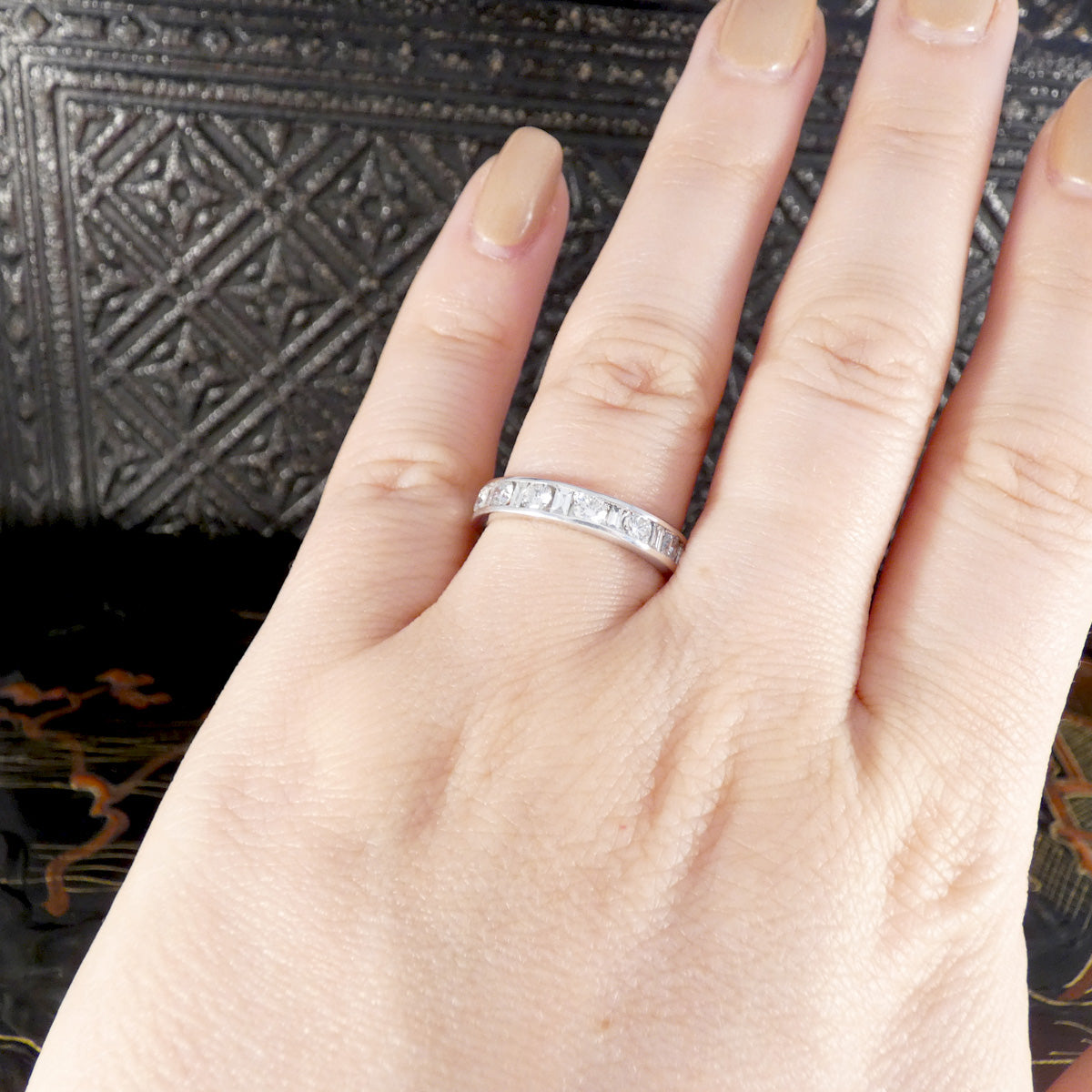A bright and sparkly full diamond eternity ring in 18ct white gold shown on the finger for a size reference.