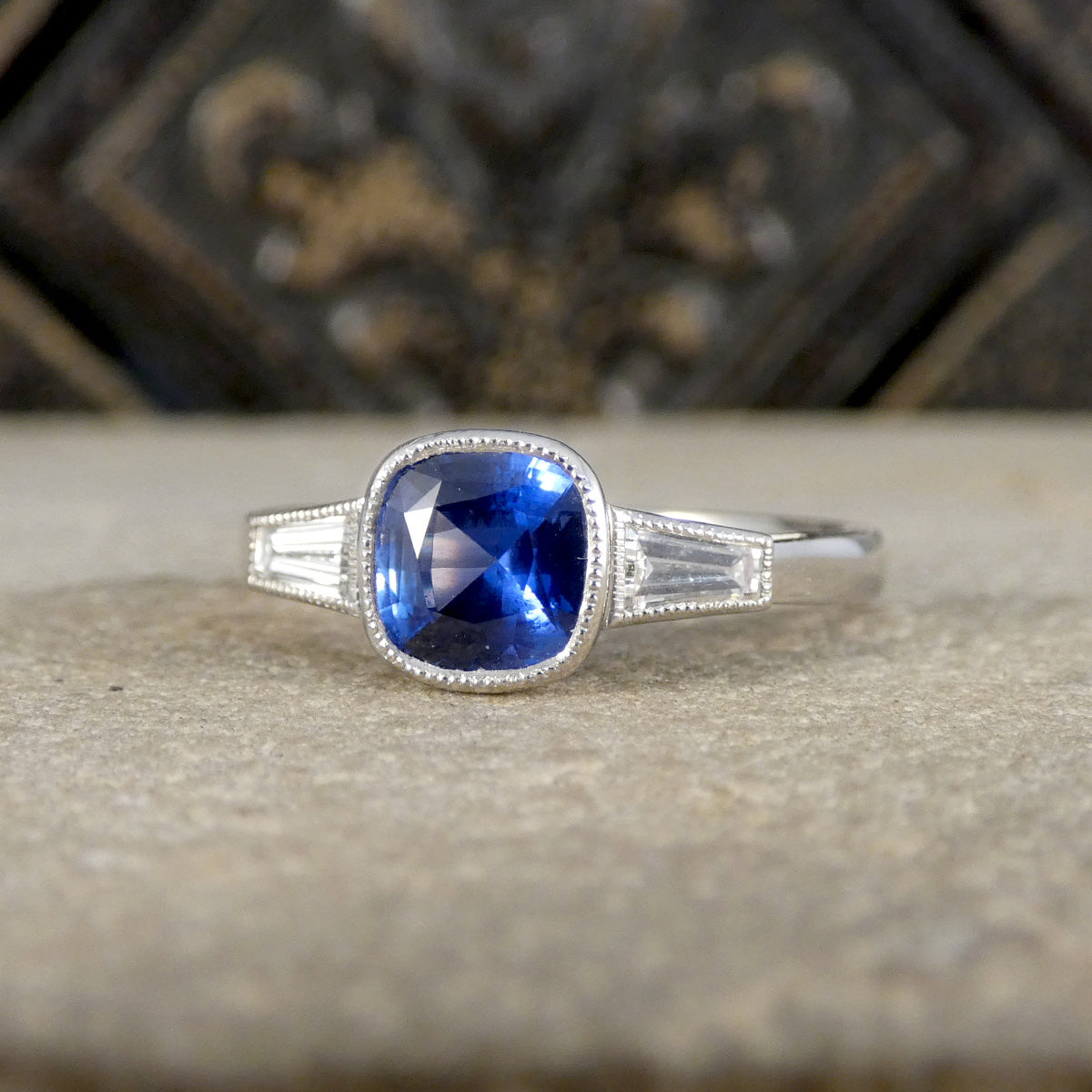 Sapphire and Tapered Baguette Cut Rub Over Set Ring in Platinum.