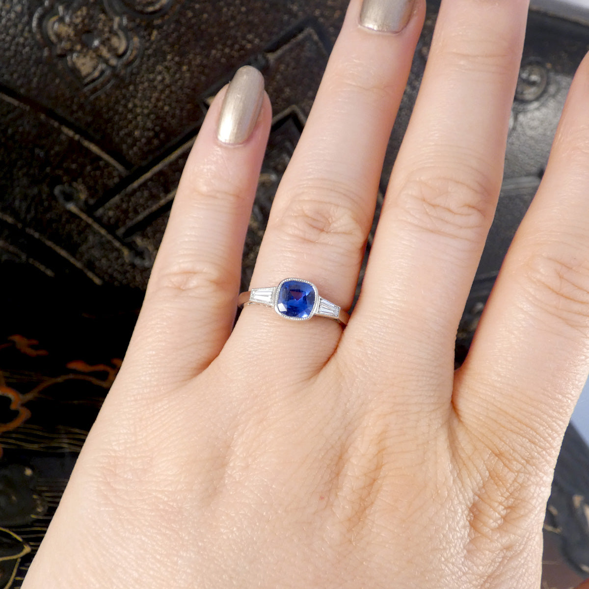 Sapphire and Tapered Baguette Cut Rub Over Set Ring in Platinum displayed on the ring finger to see how it looks when worn