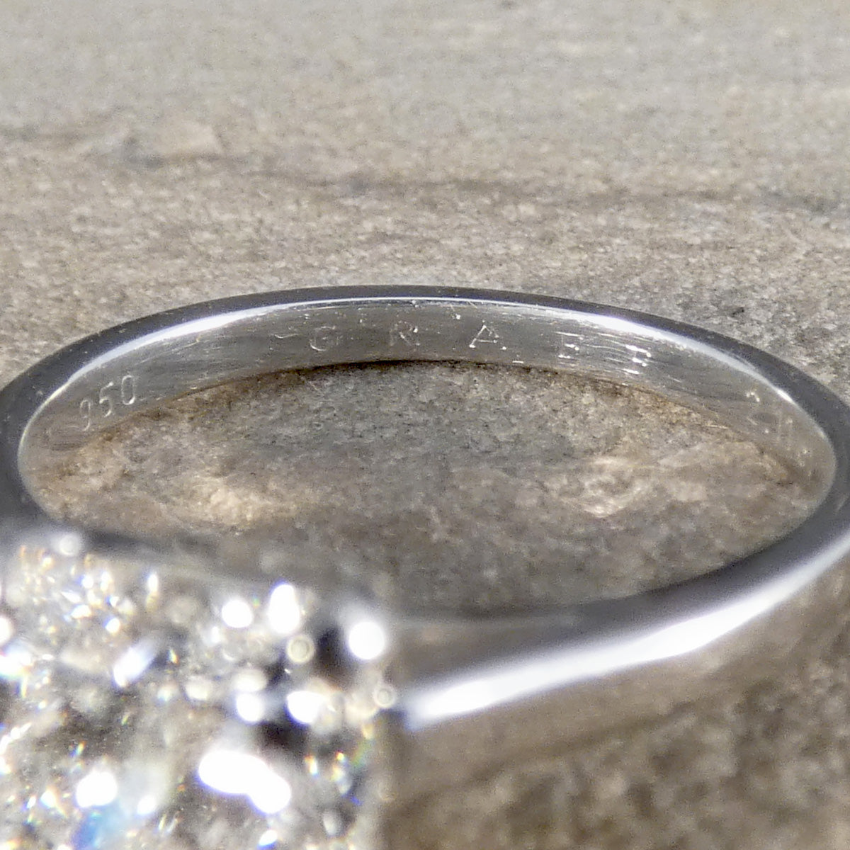 Close-up of a Platinum ring with '950' on a textured surface with GRAFF engraved on the inner band.