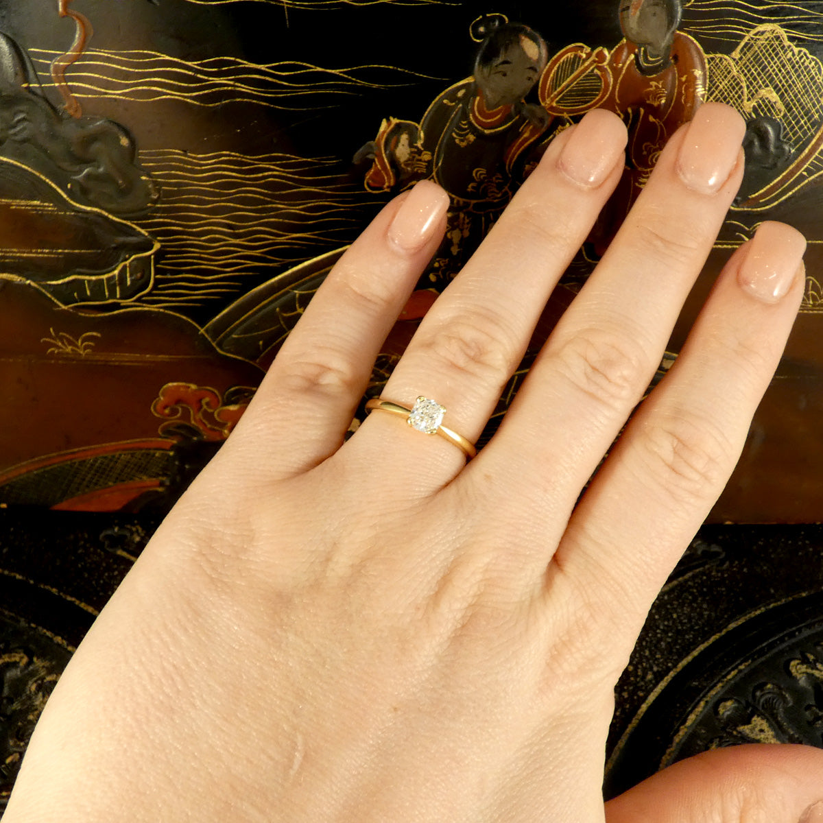 18-carat yellow gold solitaire ring with a bright and sparkly GIA-certified modified cushion-cut diamond of E colour, elegantly worn on a hand. The sleek band and radiant diamond create a timeless and luxurious look, perfect for special occasions or proposals.