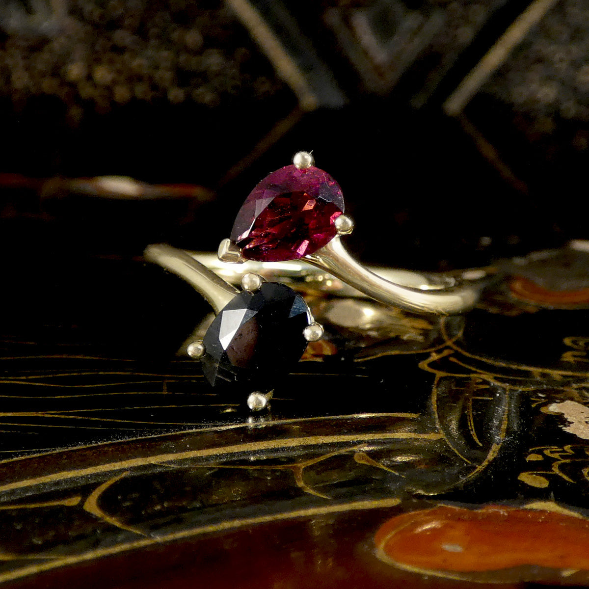 Two rings with gemstones on a decorative surface