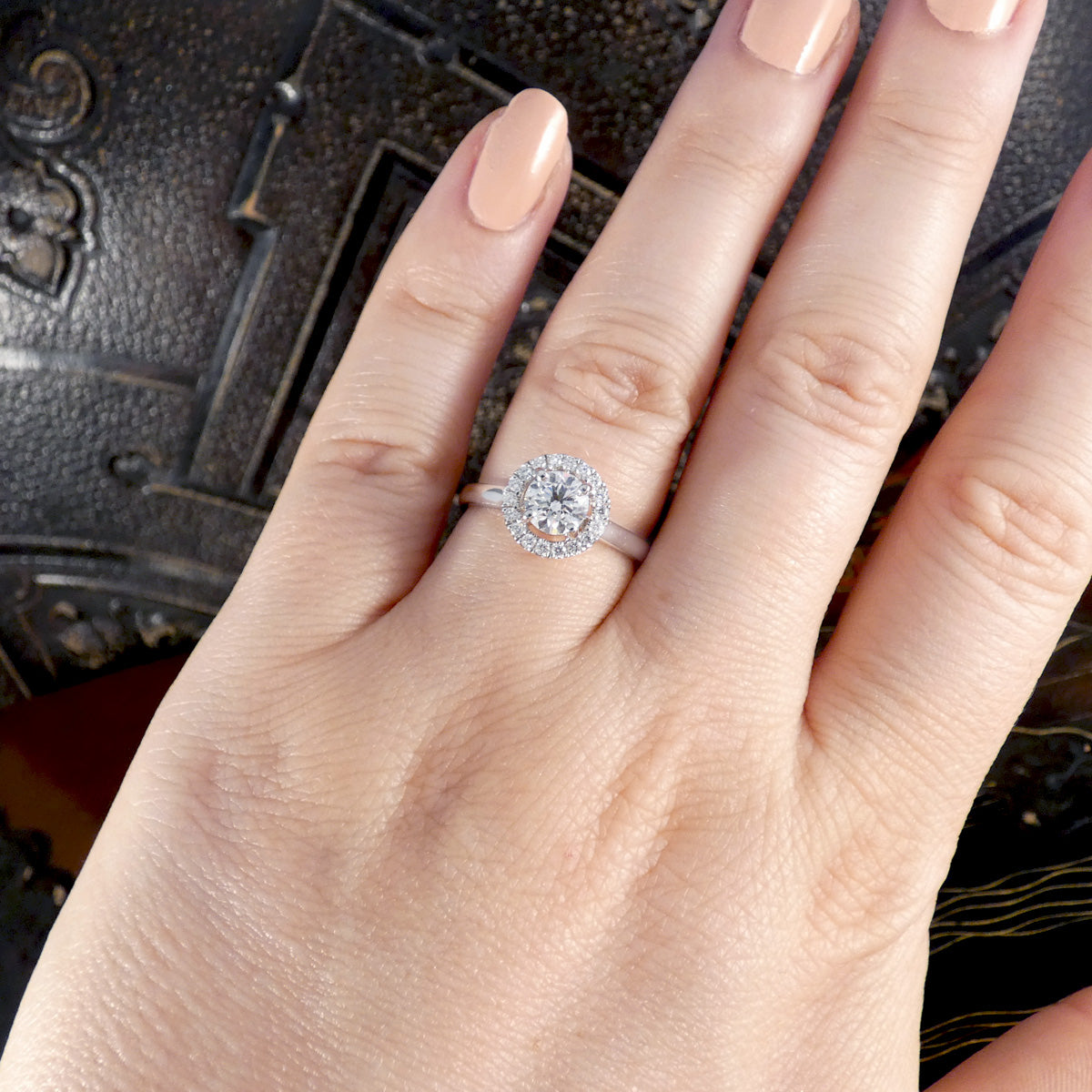 A diamond halo cluster ring with GIA certed centre stone with high colour and clarity in platinum. Shown on the hand to see size and shape reference.