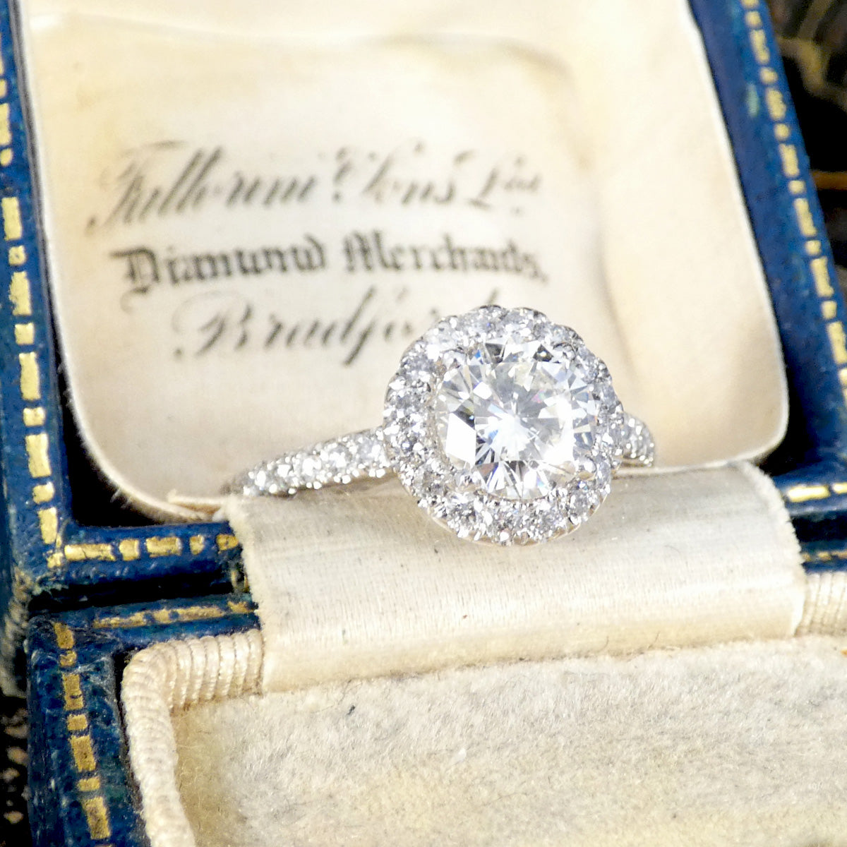 Diamond ring in an open jewelry box with visible branding