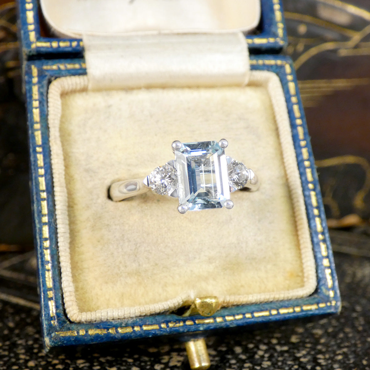 Back view of Modern Emerald Cut Aquamarine and 0.35ct Diamond Three Stone Ring in Platinum. Slightly tapered shoulders leading to accentuate the stones displayed in vintage box.
