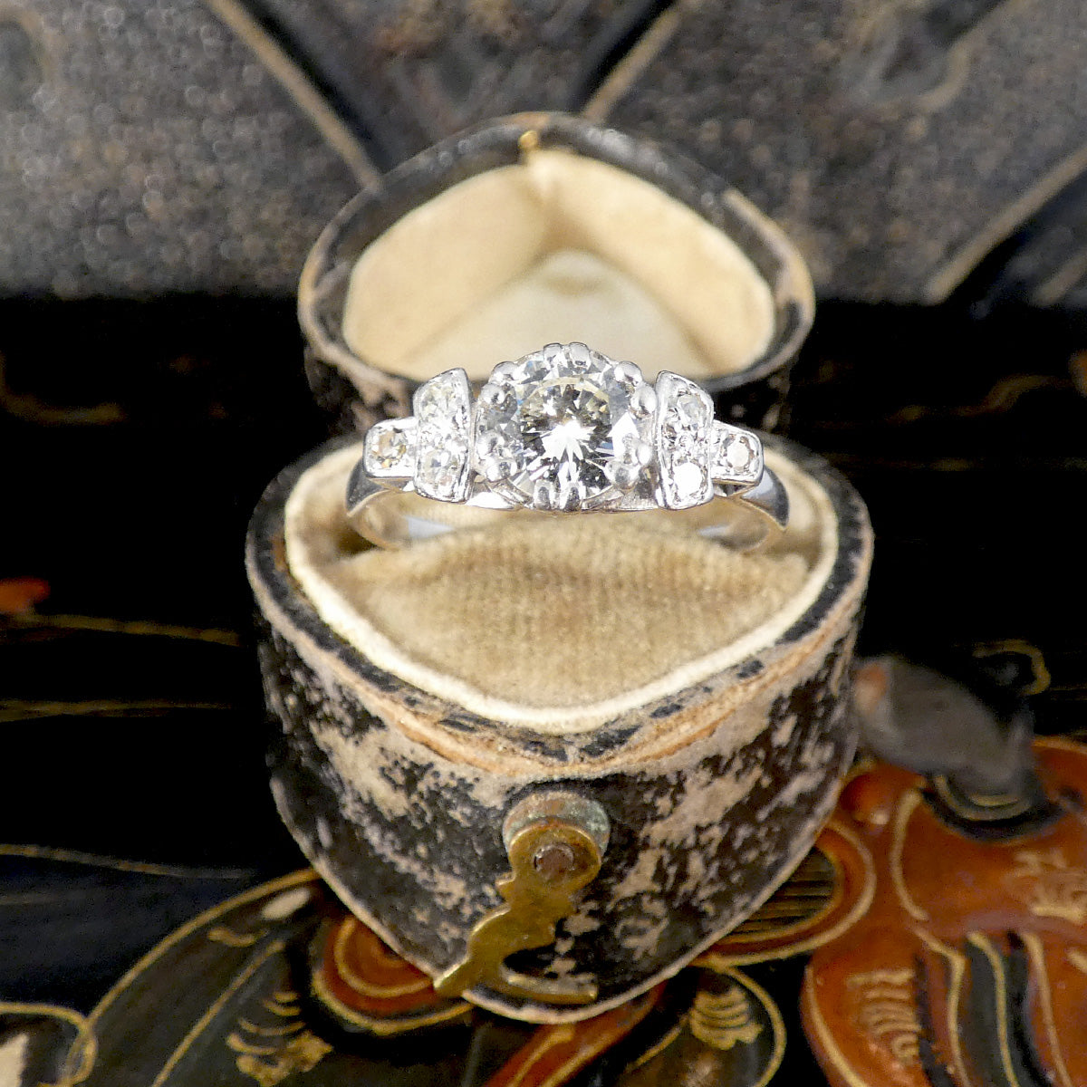 Diamond ring in an ornate box on a decorative surface