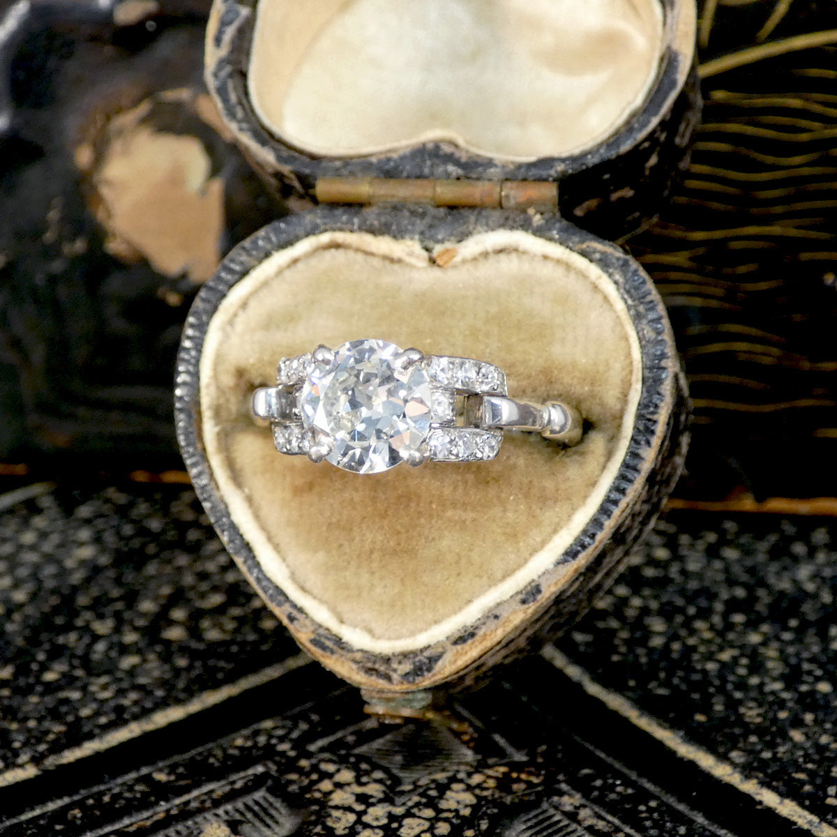 Diamond ring in a heart-shaped vintage box on a textured surface