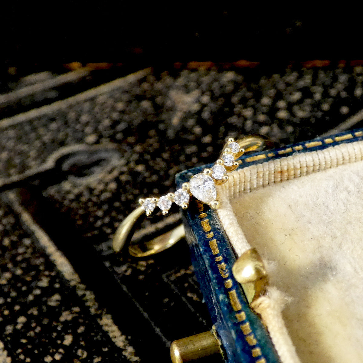 Diamond Wishbone Ring with Diamonds in 18ct yellow gold on a ornate background