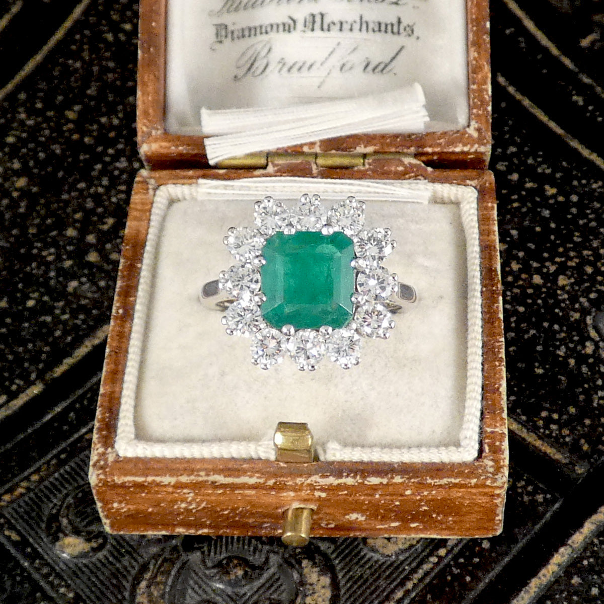A beautiful vintage pre loved ring set with an emerald and diamond cluster in Platinum and 18ct White Gold.