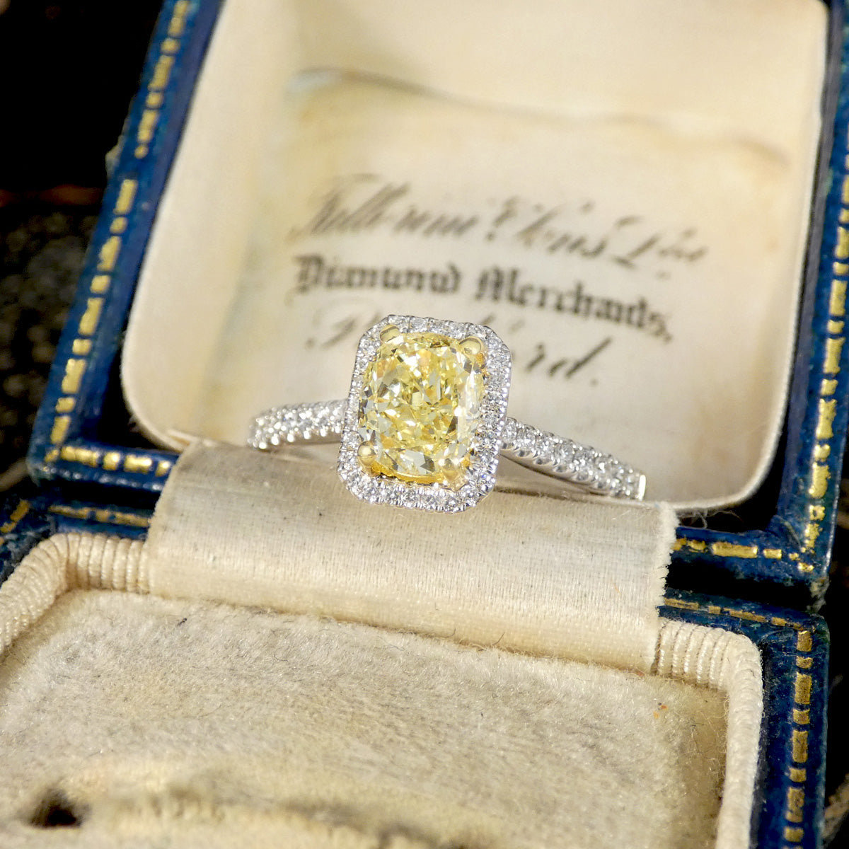 Yellow diamond ring with silver band in an open jewelry box