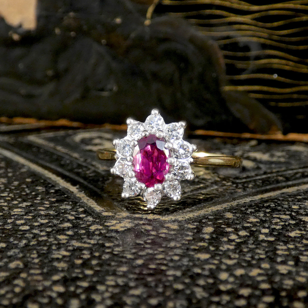 Ring with a pink gemstone and diamond stones on a textured surface