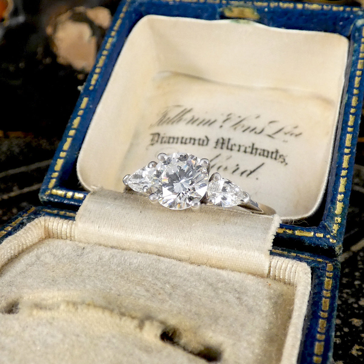 Diamond ring in an open jewelry box with visible text