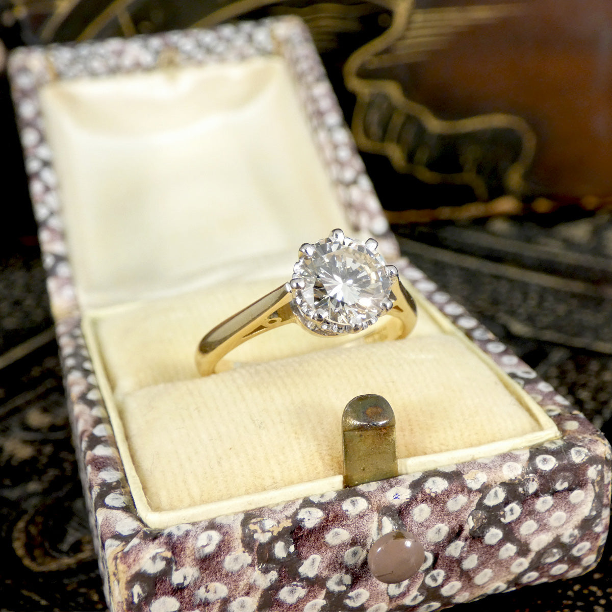 Gold engagement ring with a diamond in a decorative box