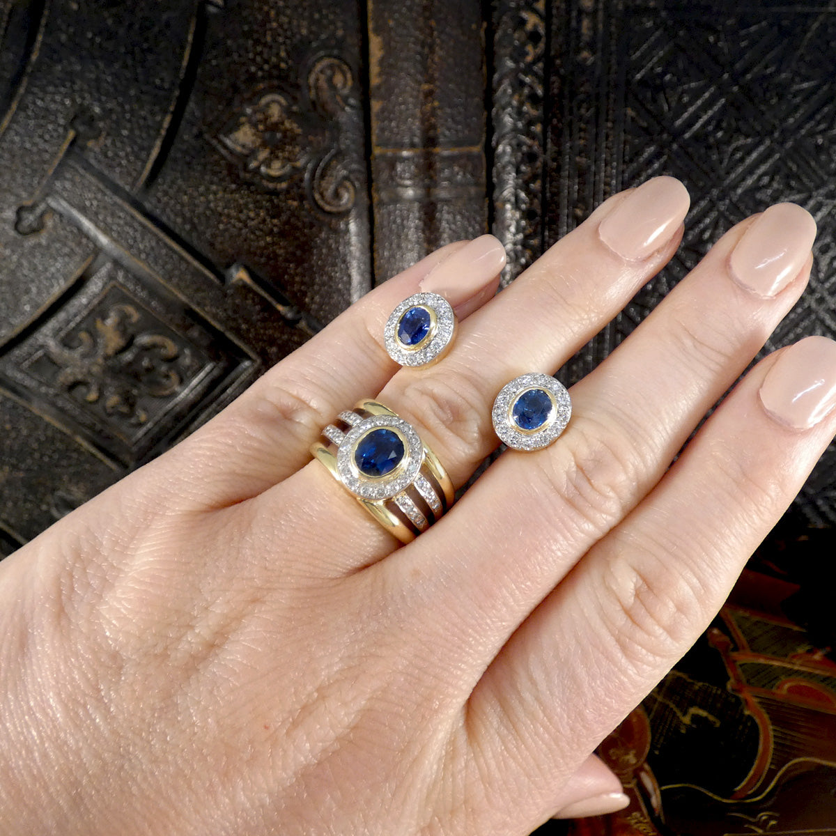A matching pair of earrings and a ring, both made in South Africa and displayed on the hand for size reference.