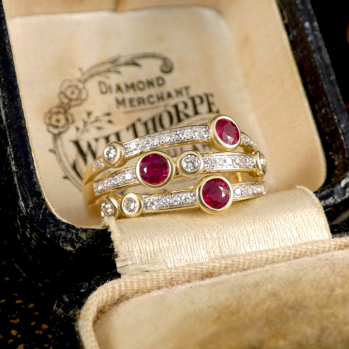 Ruby and Diamond Bubble ring from a side profile in an antique box.