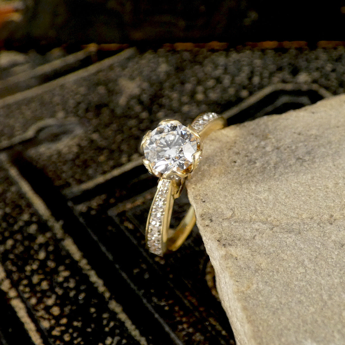Gold ring with a large diamond on a stone surface
