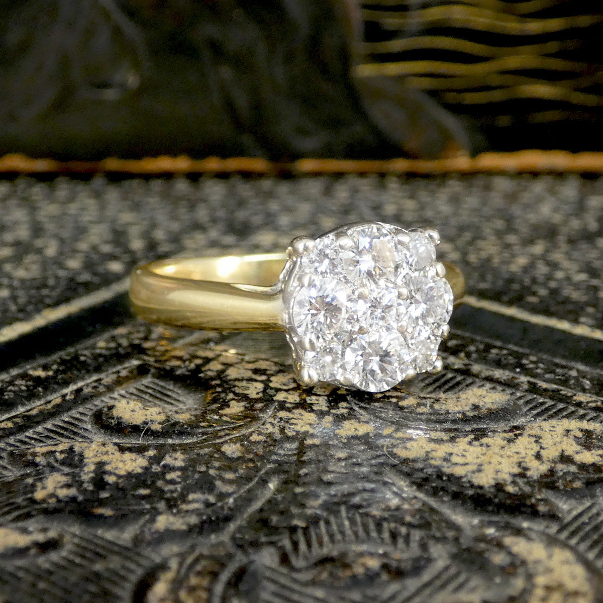 Gold ring with a large diamond on an ornate surface