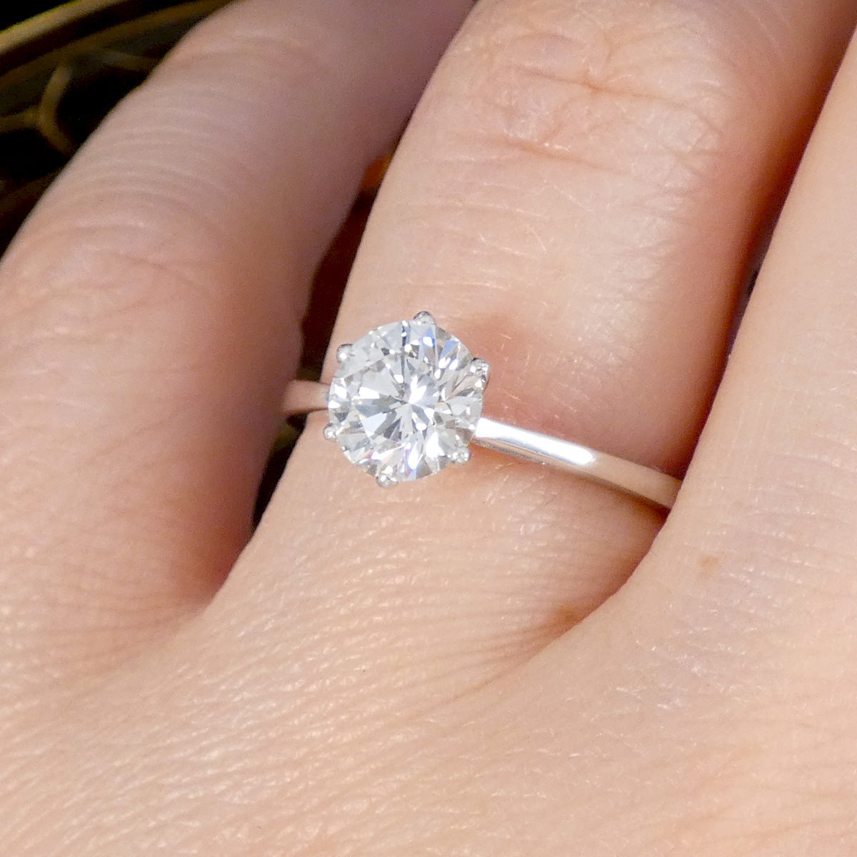 A classic and gorgeous 1.22ct Brilliant Cut Diamond solitaire engagement ring in a Platinum 6 claw setting. A close up on the finger.