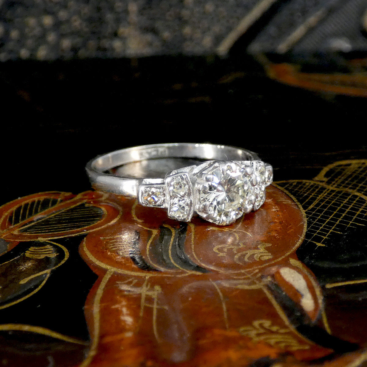 Platinum ring with gemstones on a decorative plate