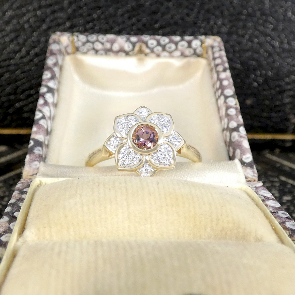 Gold ring with a colorful gemstone in an open jewelry box