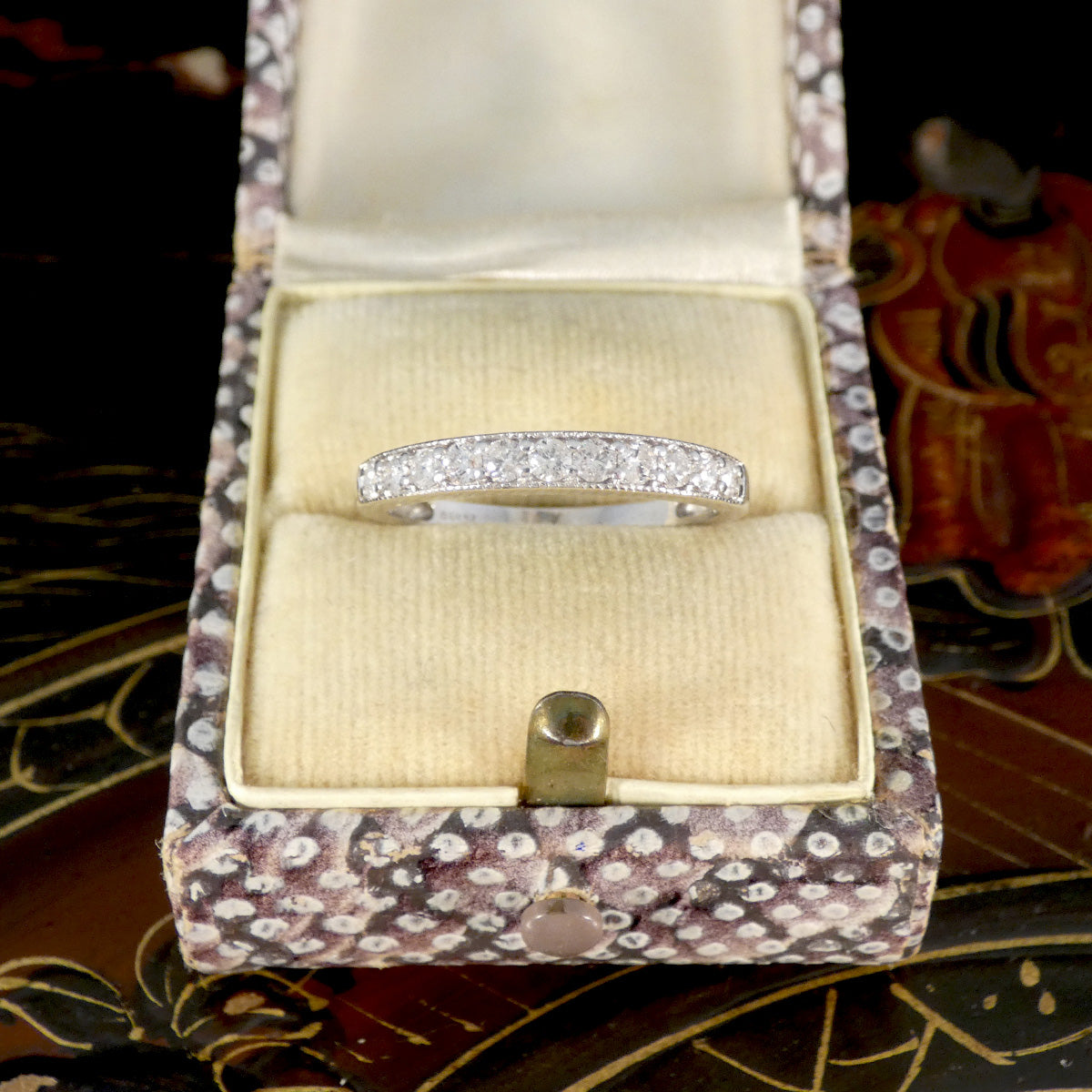 Diamond ring in a decorative jewelry box on a patterned surface
