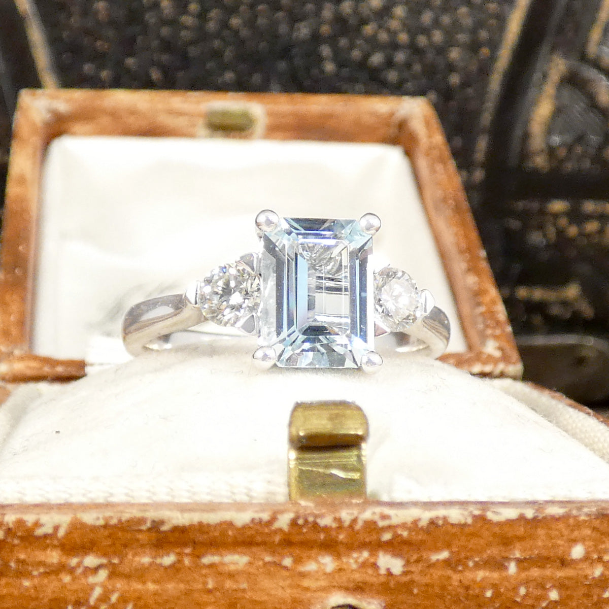 Back view of Modern Emerald Cut Aquamarine and 0.35ct Diamond Three Stone Ring in Platinum. Slightly tapered shoulders leading to accentuate the stones displayed in vintage box.