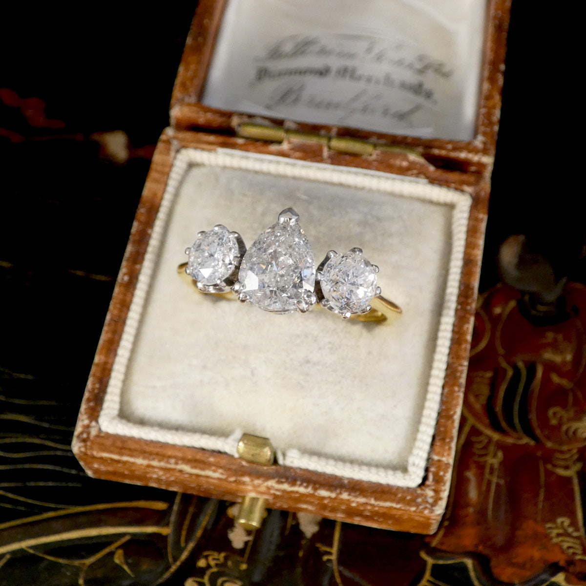 Diamond ring in an open vintage box with a decorative background
