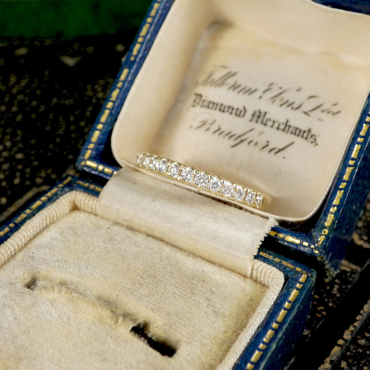 A diamond half eternity ring in yellow gold, displayed in vintage box