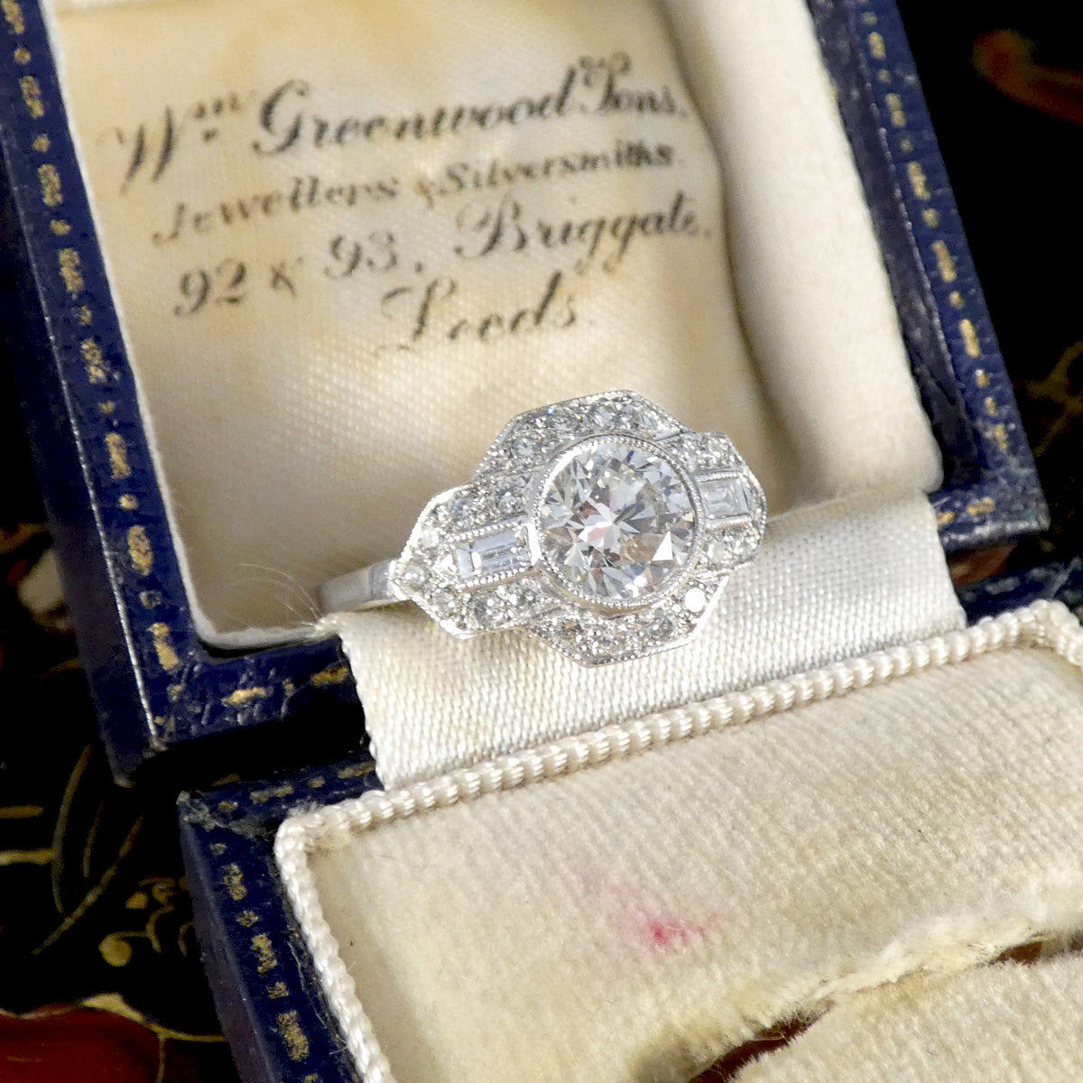 A gorgeous Art Deco inspired Diamond cluster ring in Platinum displayed in vintage box.