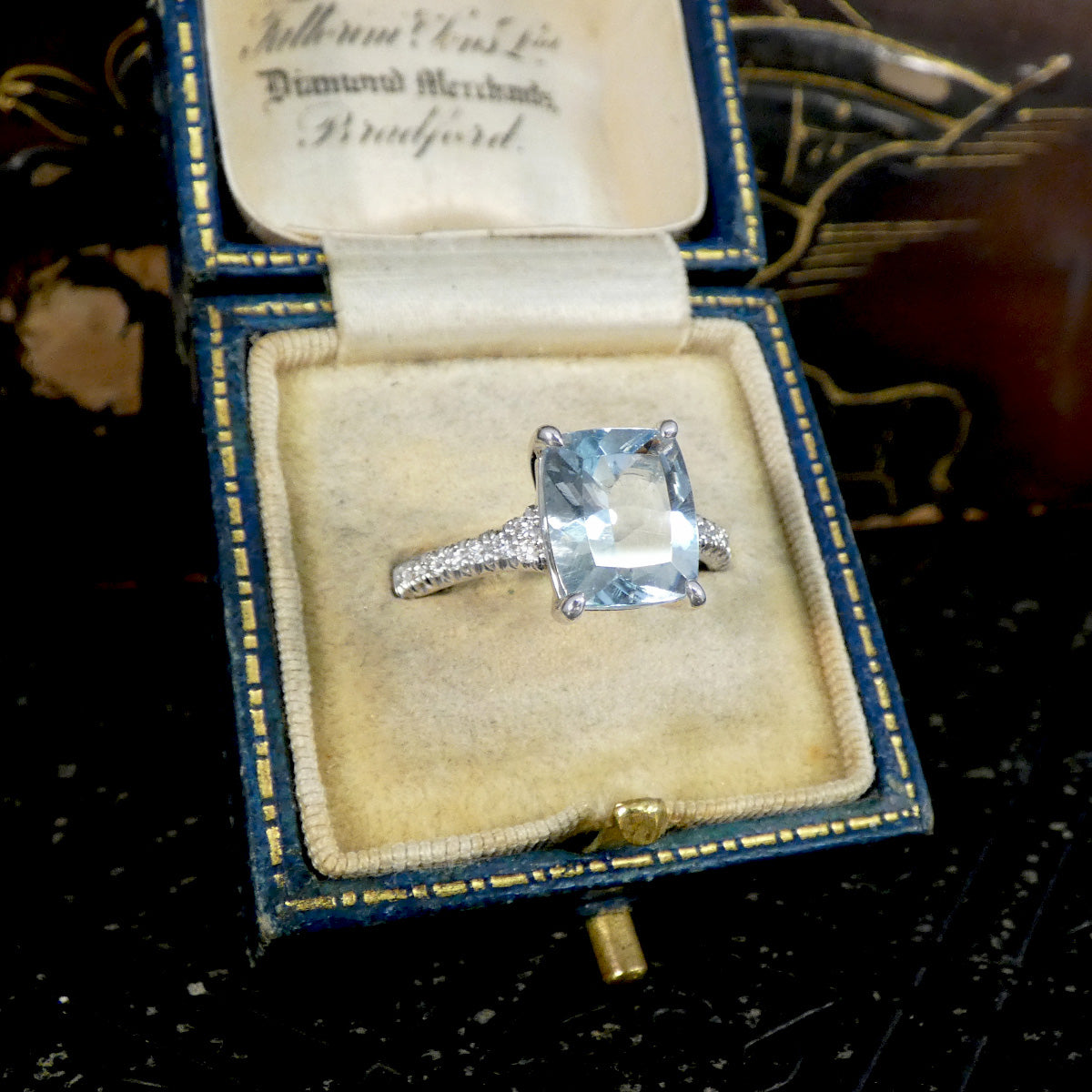 Diamond ring in an open jewelry box with visible branding
