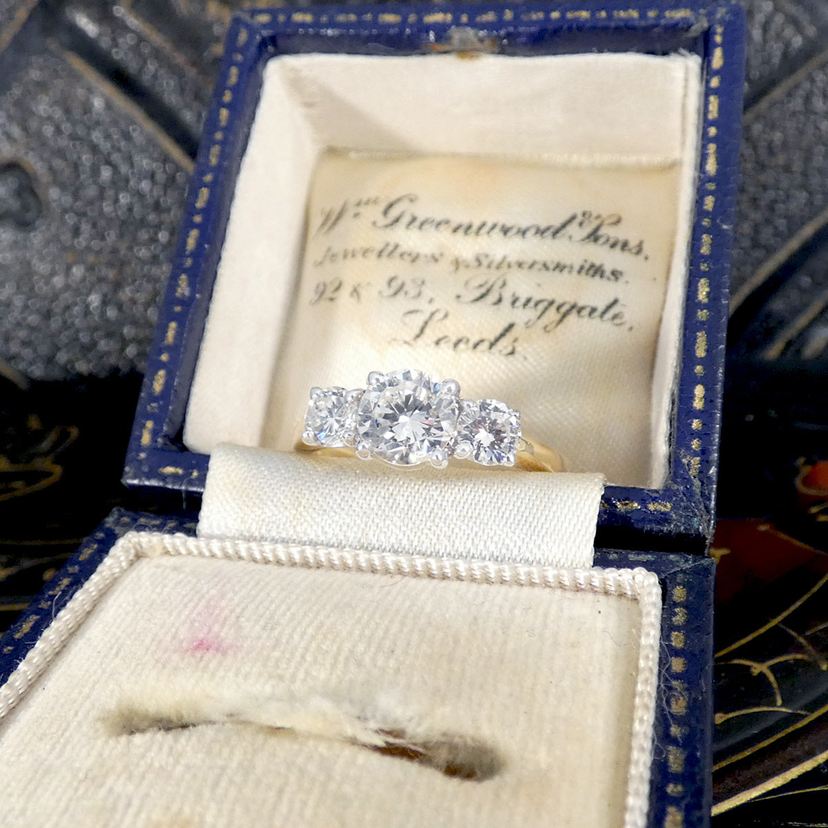 Diamond ring in a jewelry box with 'Greenwood & Sons' branding