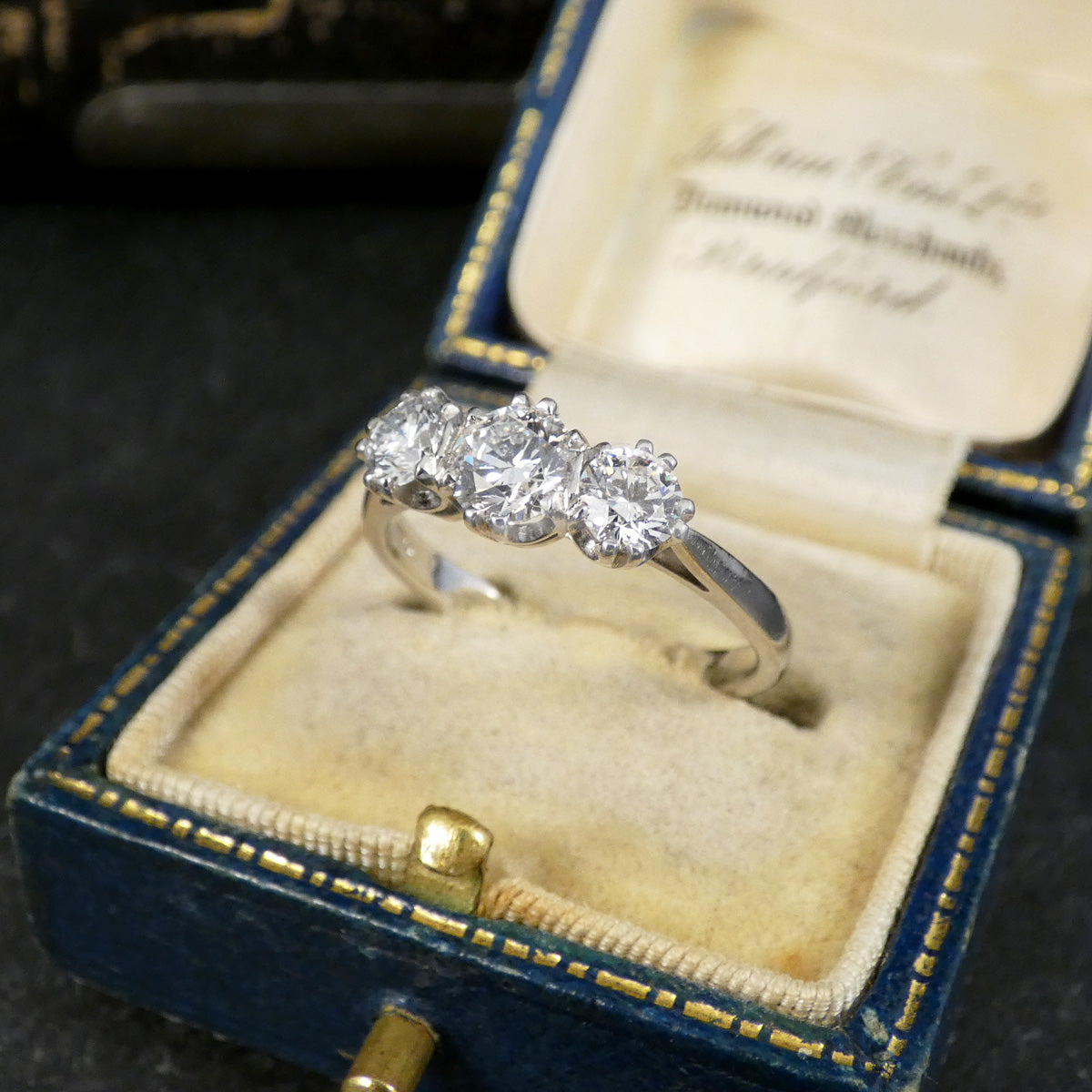 Diamond ring in an open jewelry box with a dark background