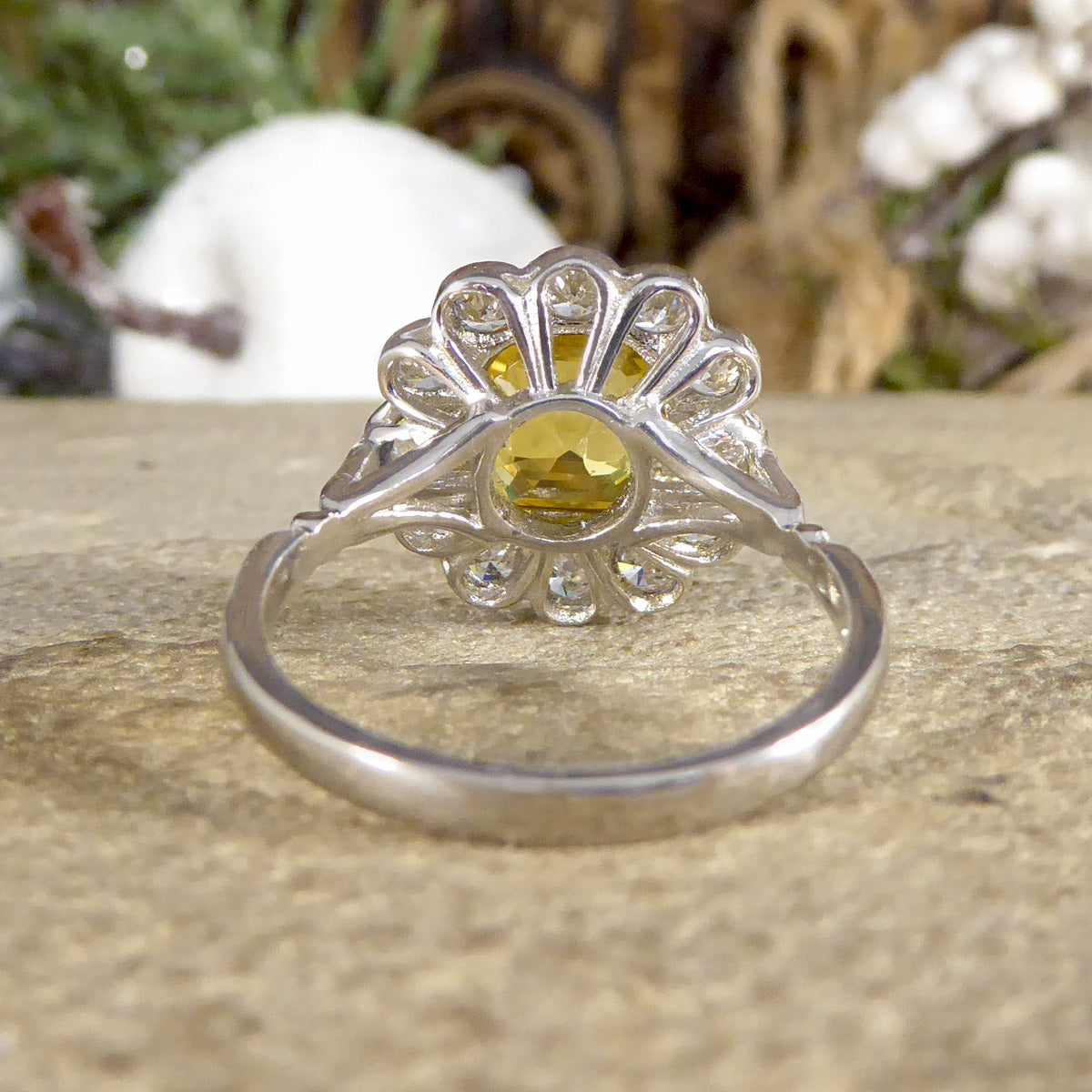 Back view of Art Deco-style ring featuring a stunning 2.10ct Asscher cut yellow sapphire, encircled by sparkling diamonds in a timeless cluster design. Showing open detailed gallery allowing light to pass through and sparkle.