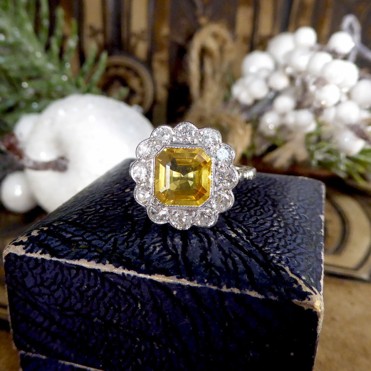 Elegant 2.10ct Asscher cut yellow sapphire and diamond cluster ring in an Art Deco-inspired design, displayed on an antique blue velvet ring box for a vintage charm.