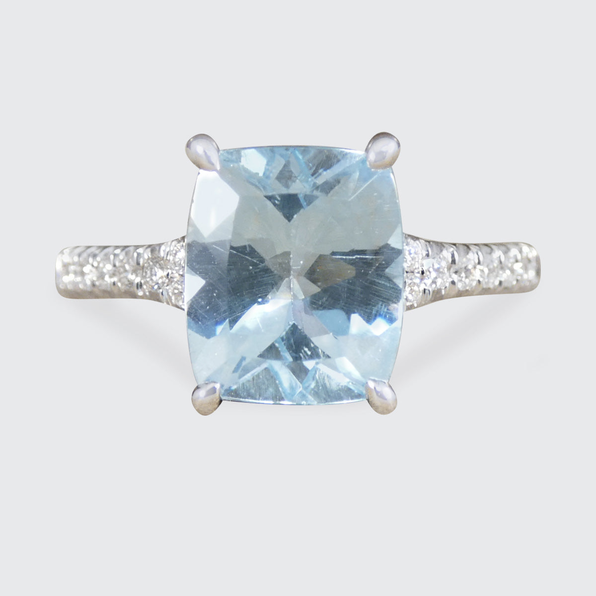 Ring with a blue gemstone and silver setting on a light gray background