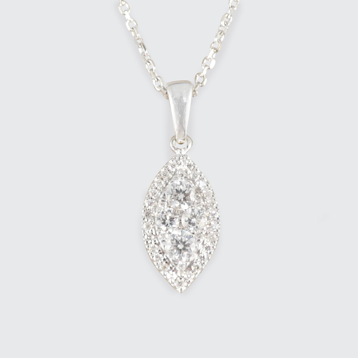 Silver necklace with a marquise-shaped diamond pendant on a light gray background