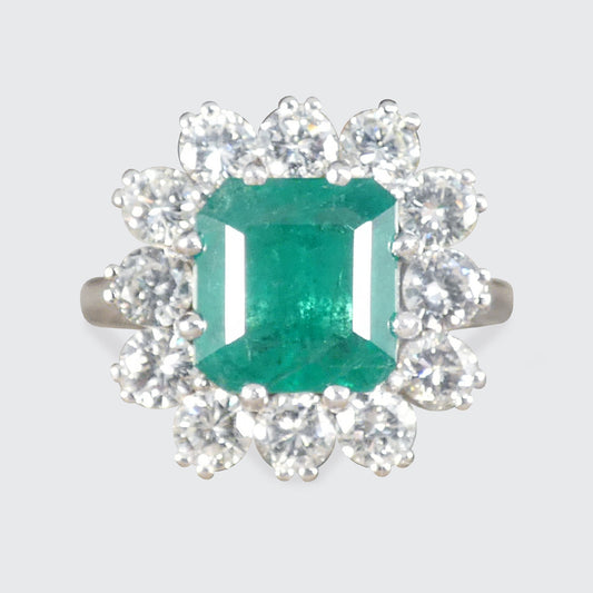 A gorgeous Emerald and Diamond cluster ring in 18ct white gold and platinum showing a gorgeous and bright emerald colour.