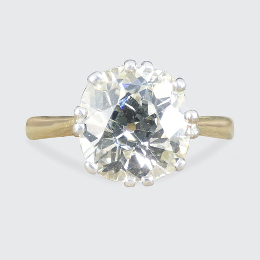 Gold ring with a large diamond on a light gray background