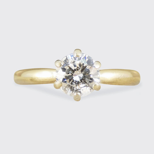 Gold ring with a diamond on a light gray background