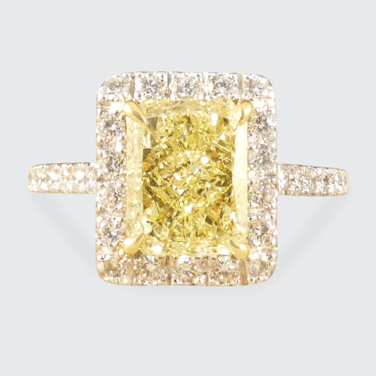 Natural Yellow Radiant Cut Diamond with GIA grading in a four claw setting. Surrounded by a halo of bright white Diamonds and Diamond set shoulders in 18ct White Gold.
