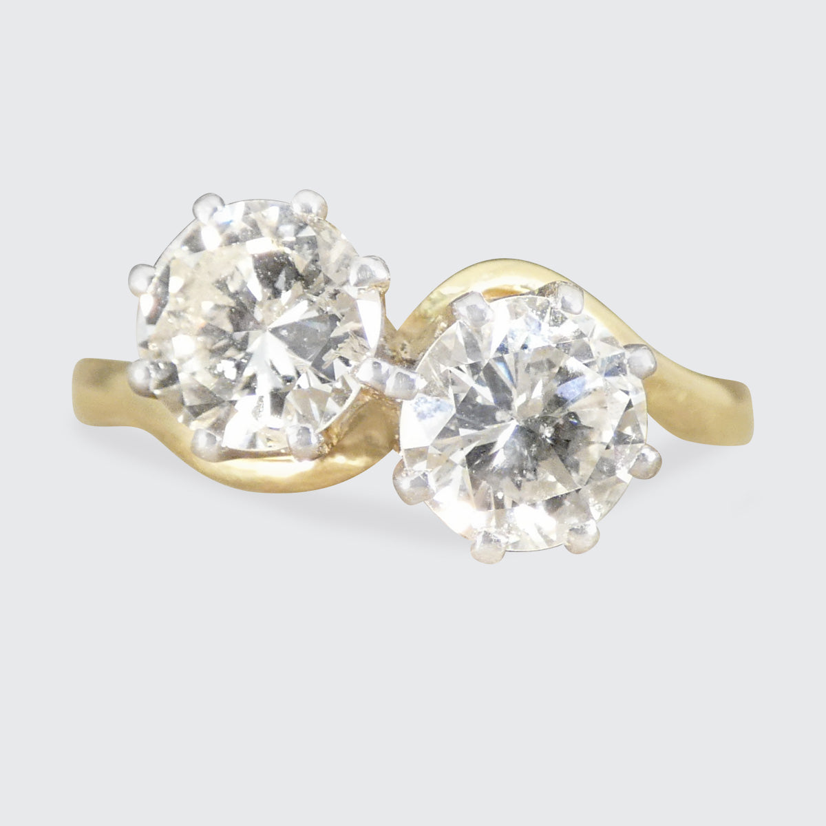 A diamond two stone twist ring in yellow gold