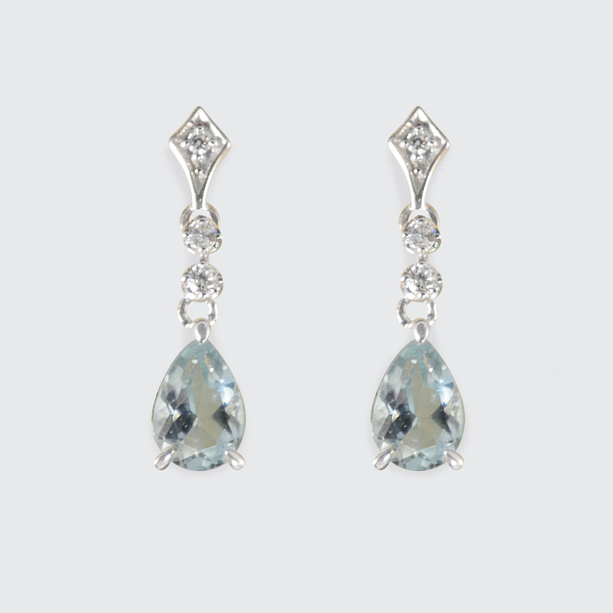 Pair of teardrop-shaped gemstone earrings with silver accents on a light gray background