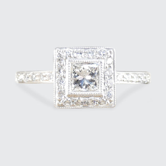 Diamond ring with a square halo on a light gray background