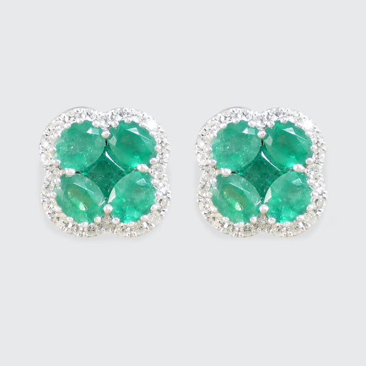 Pair of emerald earrings on a light gray background