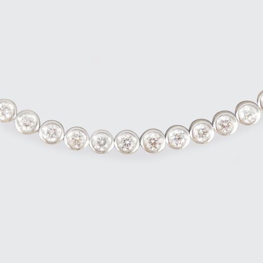 A diamond tennis bracelet in a bezel setting in Platinum