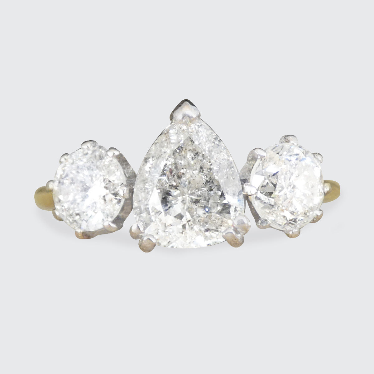 Diamond earring with three salt and pepper diamond pear-shaped diamonds on a light gray background