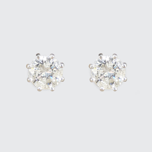Pair of diamond stud earrings on a light gray background